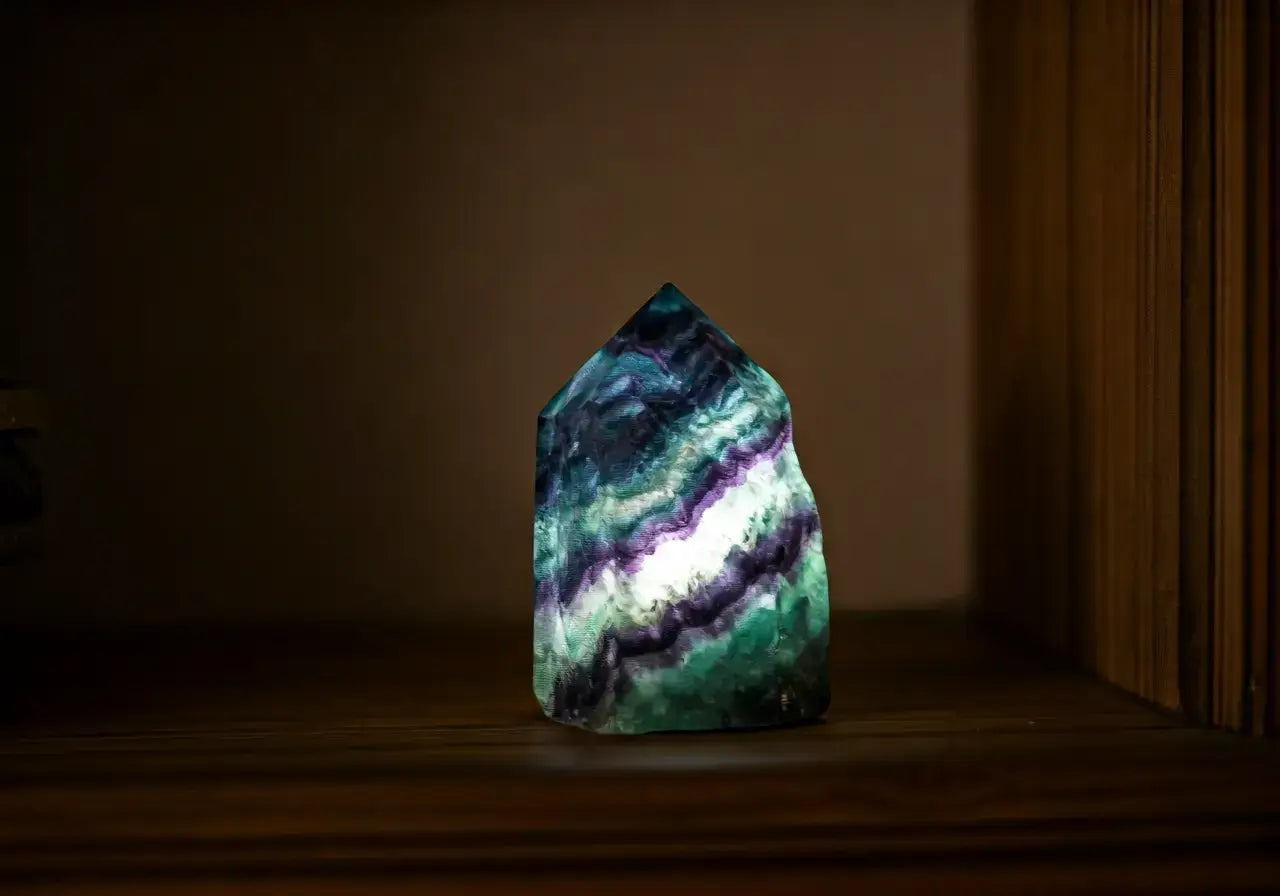 A glowing fluorite crystal on a wooden living room shelf. 35mm stock photo