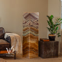Unlit Aqua Onyx floor lamp showing natural cream, honey, brown, charcoal, and subtle aqua mineral coloring