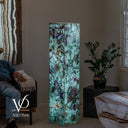 Illuminated natural Fluorite stone tower showing large green crystal formations with purple mineral accents
