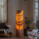 Sculptural Miami Sunset Onyx floor lamp glowing with golden amber, cream, charcoal, and burgundy chevron patterns