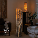 Natural Tangerine Onyx tower lamp glowing warmly with broad illuminated stone faces and dark contrasting banding