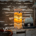Decorative lamp with multicolored stone pattern on a wooden surface with rustic background