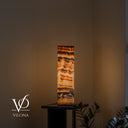 Handcrafted Sahara Onyx cylinder lamp glowing through ivory, amber, and chocolate-brown mineral bands