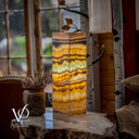 Decorative lamp with multicolored striped pattern on a wooden surface, blurred background
