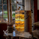 Decorative lamp with multicolored pattern on a wooden surface, blurred indoor background