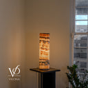 Sahara Onyx nightstand lamp lit from within to reveal warm amber translucency and dark mineral lines