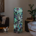 Illuminated fluorite crystal floor lamp glowing with green, turquoise, and violet-purple natural mineral formations