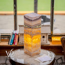 Decorative lamp with multicolored stone pattern on a round table.