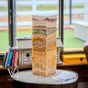 Decorative stone column on a round table with books in the background