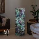 Sculptural fluorite floor lamp glowing through green and lavender stone with charcoal mineral lines