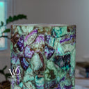 A lamp base made of polished purple and green Fluorite crystal, featuring a multicolored natural pattern with purple, green, and brown tones. Hand made by Vilona Family