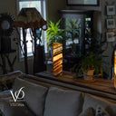 Living room with a lamp on a table and a couch in the foreground, featuring the Vilona brand logo.