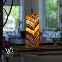 Decorative lamp with layered design on a table in a blurred indoor setting