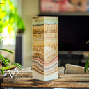 Decorative lamp with multicolored stone pattern on a wooden surface, blurred indoor background