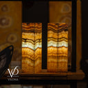 Two onyx stone lamps with a blurred background, featuring the Vilona brand logo.