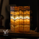 Decorative stone with layered pattern on a dark background, branded 'Vilona'.