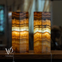 Two layered stone lamps with a blurred background, featuring the brand 'Vilona'.