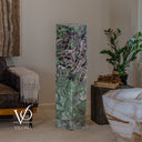 Unlit Fluorite floor lamp beside a leather sofa, with natural mineral patterns visible from top to base.