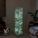 Green Fluorite tower glowing through translucent crystal sections with charcoal lines and warm tan mineral accents.