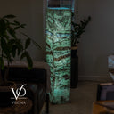 Full-height angled view of the glowing Fluorite floor lamp showing its green stone faces and 10-inch-square form.