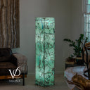 Angled view of a glowing Fluorite tower with large pale green formations and blue-green accents across two sides.