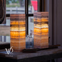 Decorative lamp with layered design on a surface near a window, featuring the brand 'Vilona'.