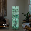 Illuminated green Fluorite floor lamp with turquoise bands across the middle and dark mineral detailing near the base.