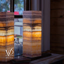 Decorative lamp with multicolored layers on a wooden surface, blurred background