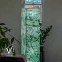 Upper detail of a glowing Fluorite tower with broad mint-green sections, dark mineral lines, and pale blue banding.