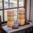 Two stacked stone columns on a table with a window in the background