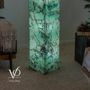 Lower detail of the illuminated Fluorite floor lamp showing aqua-green stone, dark veining, and blue-violet accents.
