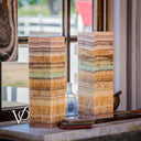 Decorative stone vases with multicolored stripes on a surface with a blurred background
