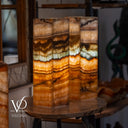 Decorative lamp with layered design on a wooden table, blurred background
