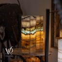 Decorative lamp with multicolored layers on a wooden surface, blurred background