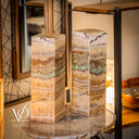 Decorative marble columns on a round stone table with a blurred background