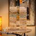 Two marble columns on a table with a decorative wall in the background, featuring the Vizcaya logo.