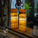 Two onyx stone lamps on a wooden surface with blurred background