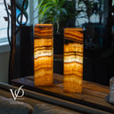 Two onyx table lamps on a wooden surface with blurred background