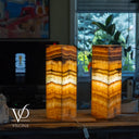 Two onyx-styled lamps on a wooden surface with a blurred background