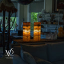 Two illuminated lampshades on a table with a blurred background