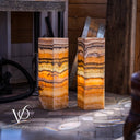 Two stone columns with colorful layers on a stone floor, branded 'Vilona'.