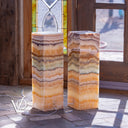 Two marble columns with a stained glass window in the background