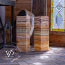 Two stone columns with a stained glass window in the background