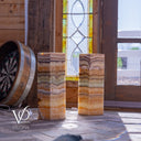 Two stone pillars with a decorative window and dartboard in the background.