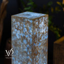 Decorative stone block with a speckled pattern on a dark background, featuring the brand 'Vilona'.