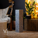 Decorative stone pillar with a plant and chair in a room setting, featuring the brand 'Vilona'.