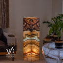 Illuminated Aqua Onyx tower floor lamp with a pale aqua band, golden lower layers, and rose and charcoal patterns above.