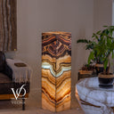 Glowing Aqua Onyx tower viewed at an angle, with a dipping aqua band above flowing amber and cream layers.