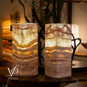 Two onyx stone lamps with a decorative background featuring other lighting fixtures.