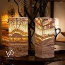 Two stone-patterned lamps on a table with blurred background